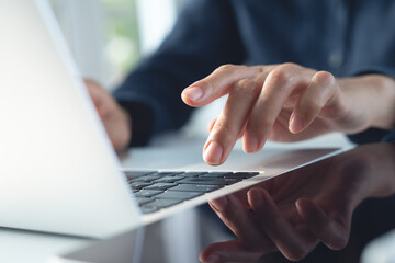 Close up, business woman hand typing, working on laptop computer with digital tablet on office table, surfing the internet, searching the information, business technology, remote work concept
