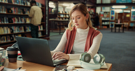 Student, woman and typing on laptop in library for education, learning or notes revision in...