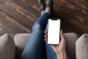 Relaxed Woman Sitting Cross-Legged with Smartphone in Cozy Indoor Atmosphere