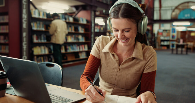 University, headphones and woman on laptop in library for online assignment, studying and test. College, happy and student with music on computer for research notes, education and learning on campus - Powered by Adobe