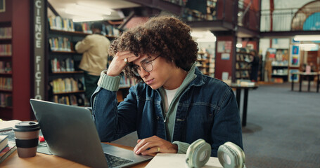 Laptop, tired and man with headache in library for exam pressure, fatigue or pain in college....