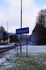 Train station sign in winter landscape with light snow covering ground and trees, rural Transport concept reflecting serene and peaceful travel atmosphere in Adršpach location