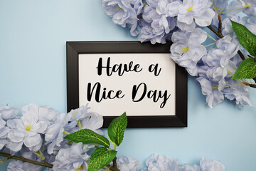 Have a Nice Day text with flowers decoration on light blue background