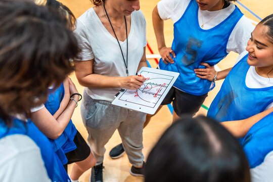 Female basketball coach explaining game strategy to team
