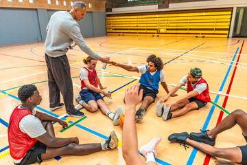 Basketball coach giving water to thirsty players during training