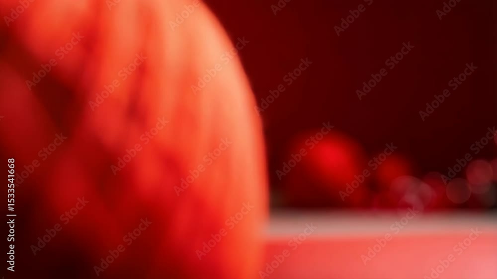 Poster macro image showcasing a vibrant red ball of yarn on a matching surface, with soft bokeh lights in t