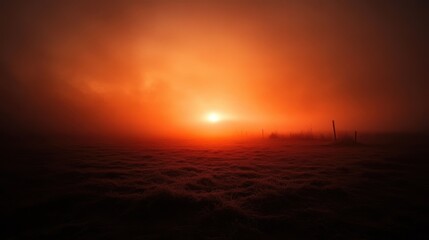 Obraz premium Foggy empty field at sunrise with a soft orange glow piercing through the mist, mysterious and peaceful.