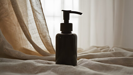 Black dispenser bottle backlit with golden fabric