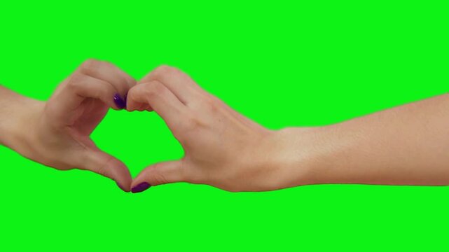 Heartfelt Gesture: A pair of hands forms a heart shape against a vivid green background, symbolizing love and connection. This image captures a moment of tenderness and affection.