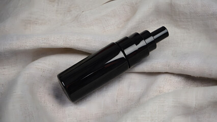 Cosmetic airless bottle on beige linen surface