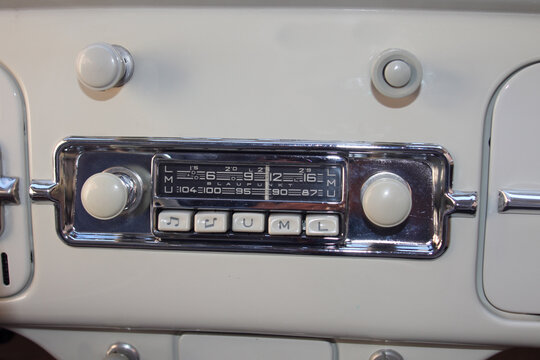 Fototapeta old car radio from the sixties in a vintage car with metal dashboard and chrome trim