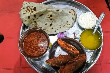 Tilapia fish fry in a plate. prepared hot and spicy.Tilapia masala spicy curry meat food in a plate with rice and naan bread