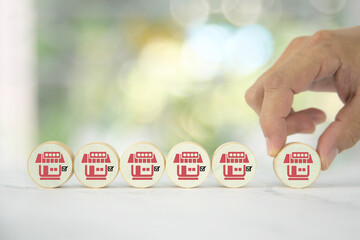 Hand chooses wooden toy stack with franchise business store for franchising to growth branch...
