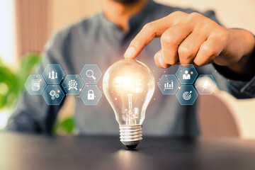 Close up hand choose light bulb or lamp with bright and business icons for human resources or...