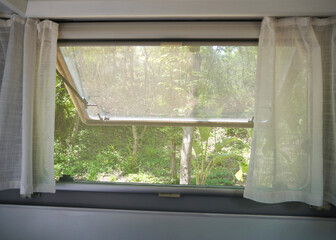 Fototapeta premium Summer Breeze Through Camper Window with Mesh Screen.