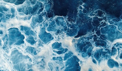 Obraz premium High-angle view of churning ocean waves. White frothy water patterns on deep blue ocean surface