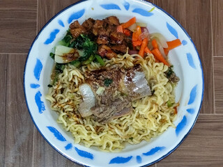 Guring beef noodle soup, equipped with delicious toppings, served on a traditional Indonesian iron plate.