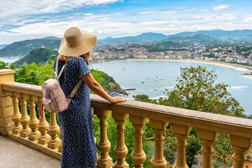 Female tourist with her back contemplated the wonderful views of La Concha Bay from Mount Igueldo.