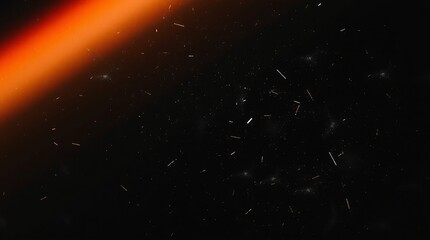 Abstract orange light leak on dark background with dust and particles