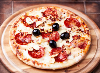 Pizza with salami and mozzarella cheese. Wooden background. Soft focus. Close up.	