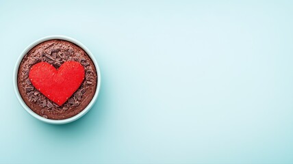 Obraz premium romantic chocolate soufflé topped with a red heart and chocolate shavings in white ramekin on soft pastel background