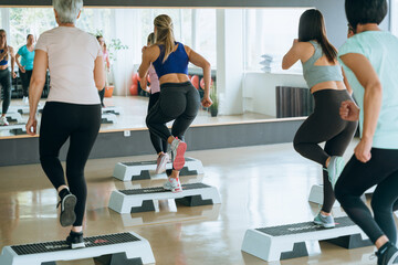 Fitness group training on step platforms in modern gym sport activity for wellness and health