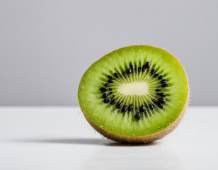 A sliced kiwi fruit showing green flesh and tiny black seeds, close-up photo, minimal white setup