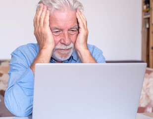A distressed man sits on a park bench, his head buried in his hands, conveying deep frustration and sadness, surrounded by autumn leaves.