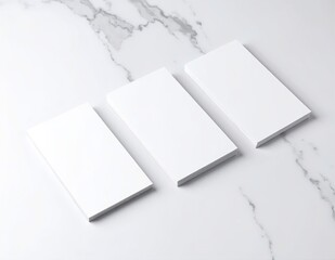 Three pristine, blank cards are elegantly arranged on a smooth, white marble surface, showcasing their clean edges and subtle shadows.
