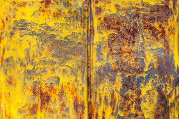 brown rusted sheet metal surface with yellow spray paint remnants