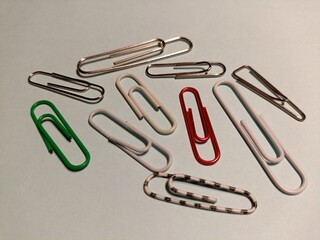 colorful paper clips, Assorted Paper Clips Holding a Light Blue Sheet of Paper.
