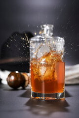 Whisky con cubetti di ghiaccio che cadono in un bicchiere su sfondo nero