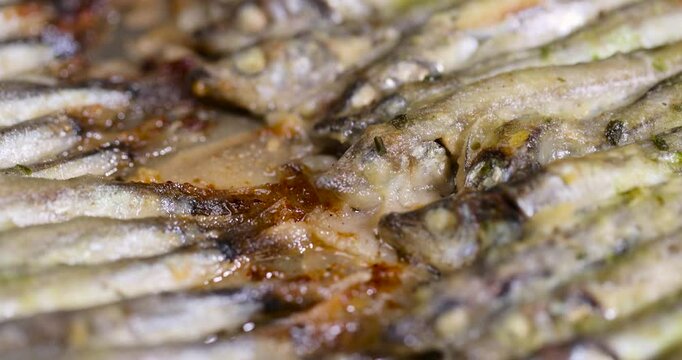 capelin fish fried in plenty of oil, stacked in rows cooked hot capelin baked in sunflower oil in the oven, close up