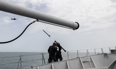 Navy soldiers fire a missile at an enemy helicopter. Military action at sea. War concept. 