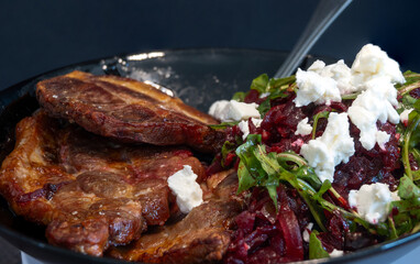 Close-up on a plate with  steaks  beetroot, salad rocket and Greek feta cheese. Food concept.