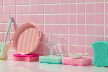 A playful arrangement of dishwashing tools like plates, bowls, brushes, and sponges, presented in...