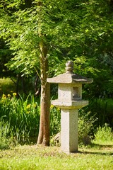A corner of a Japanese garden, a traditional sculpture. Summer time of the year