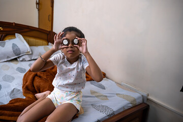 Child playing with cookies in cozy bedroom setting