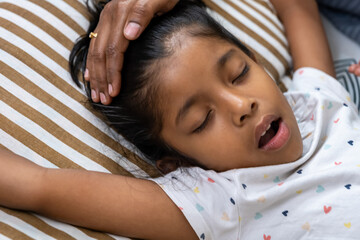Child resting peacefully on a striped pillow