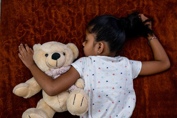 Child peacefully sleeping with teddy bear in cozy setting