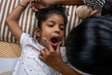 Child receives dental check-up at home during daytime