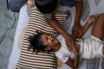 Joyful child playing and laughing at home with parent