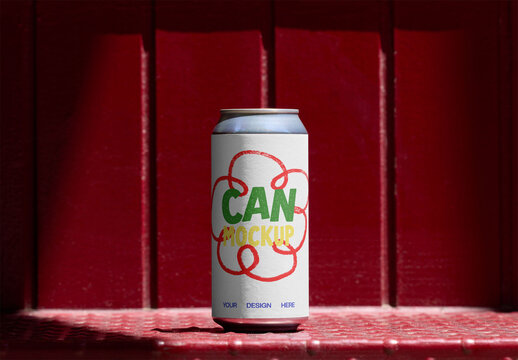 A blank can with a white label stands against a striking red wall, perfect for showcasing design ideas and branding concepts. PSD template mockup.