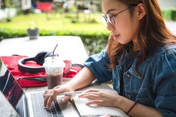Asian female collage student with laptop studying outdoor campus, back to school concept
