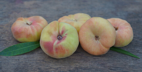 A bunch of flat peaches on a board