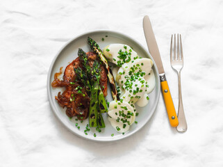 Delicious lunch and dinner - pork chop, asparagus, potatoes with yogurt sauce on a light...