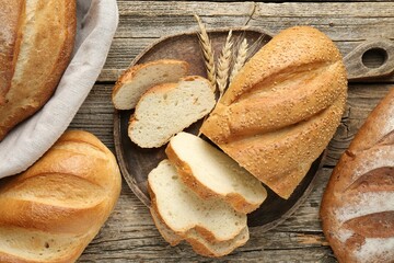 Cut bread loaf and spikes on wooden table, flat lay