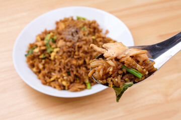 Thai style dark brown soy sauce fried rice with chicken, kale, and egg in white dish with short...