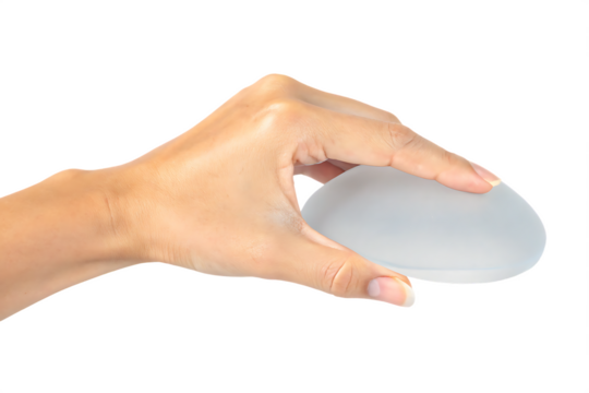 Woman's hand holding silicone breast implant isolated on a white background