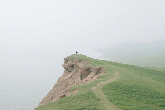 minimalist scene featuring solitary figure standing on coastal cliff in kazakhstan under overcast sky - Powered by Adobe